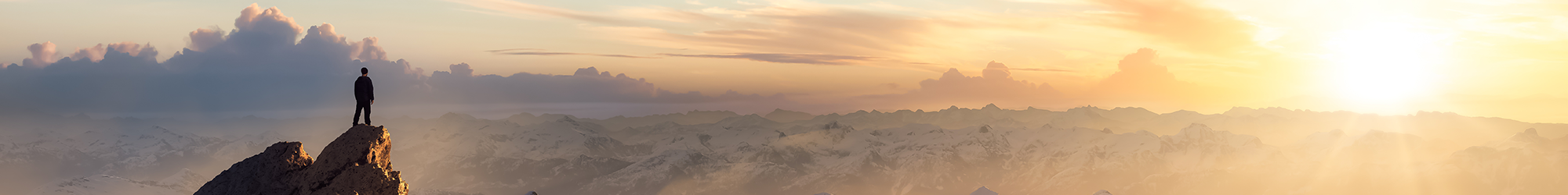 Single person atop a peak at sunset